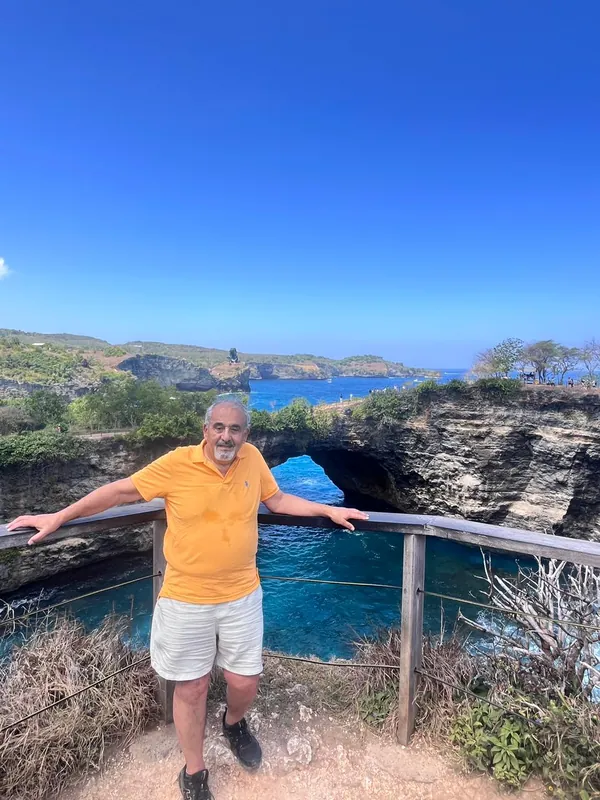 Guest standing at the natural sea arch of Broken Beach