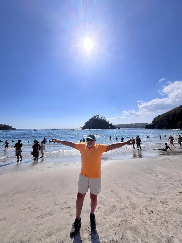 Guest with arms wide open on Crystal Bay beach