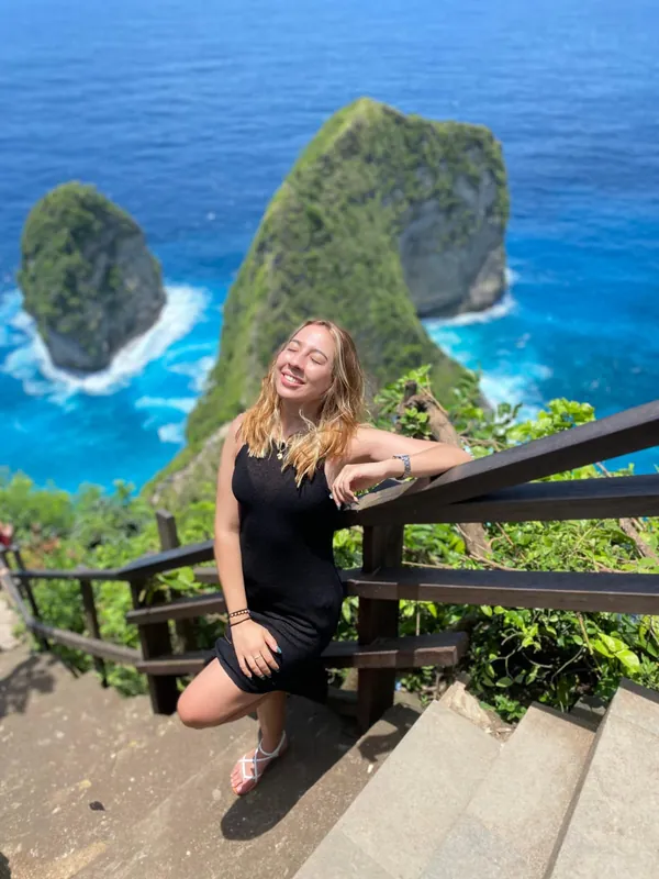 Solo traveller posing at the Kelingking Beach viewpoint